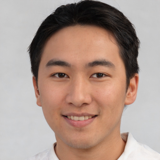Joyful asian young-adult male with short  brown hair and brown eyes