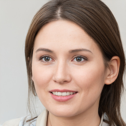 Joyful white young-adult female with medium  brown hair and grey eyes