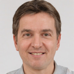 Joyful white adult male with short  brown hair and grey eyes