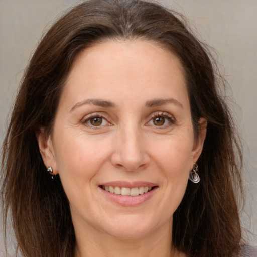 Joyful white adult female with long  brown hair and brown eyes