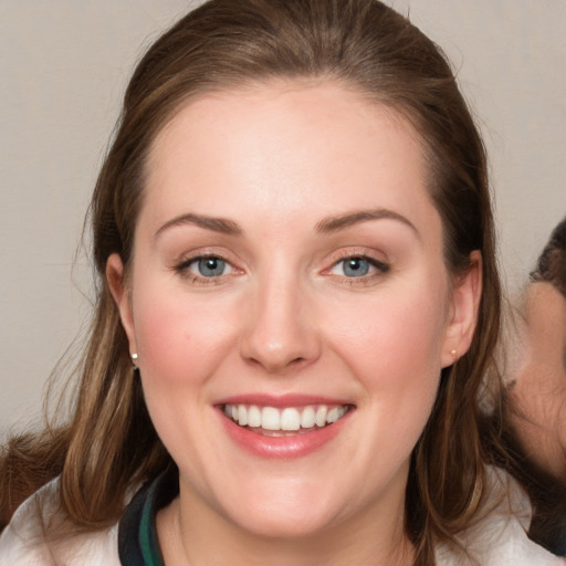 Joyful white young-adult female with medium  brown hair and blue eyes