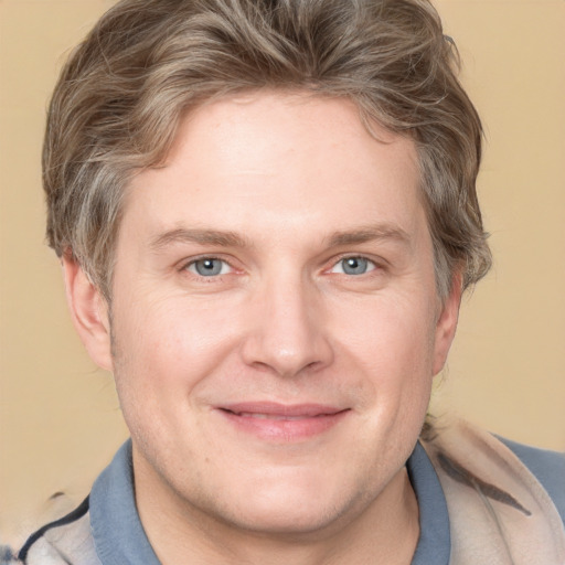 Joyful white adult male with short  brown hair and grey eyes