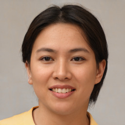 Joyful asian young-adult female with medium  brown hair and brown eyes