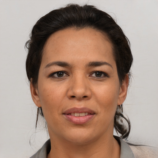 Joyful latino adult female with medium  brown hair and brown eyes