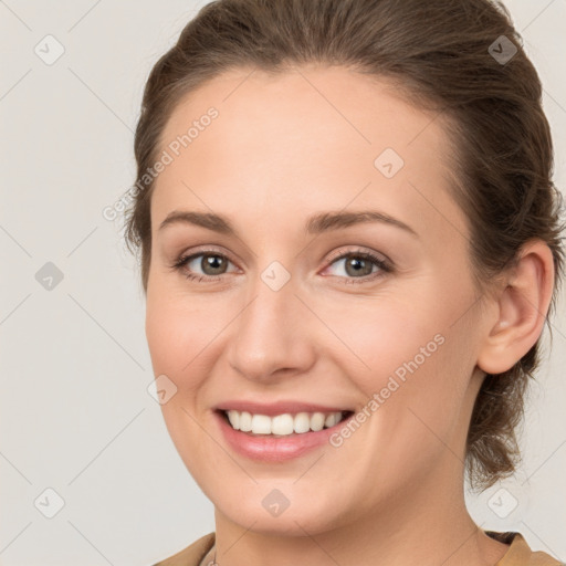 Joyful white young-adult female with medium  brown hair and grey eyes