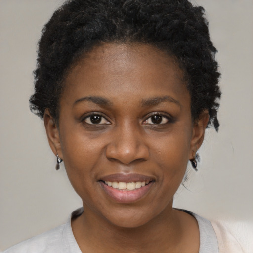 Joyful black young-adult female with short  black hair and brown eyes