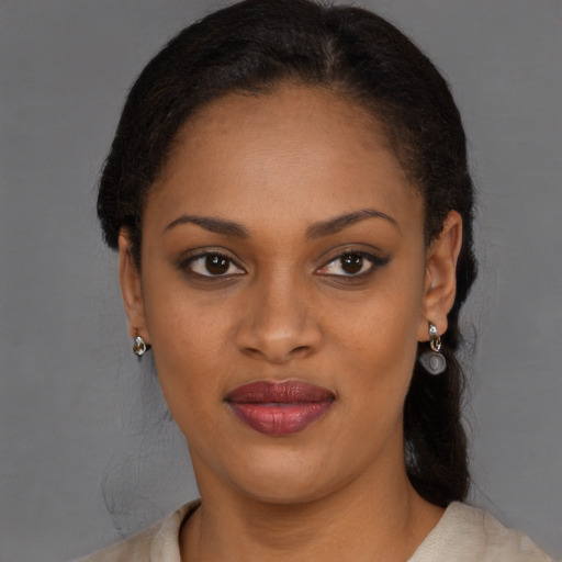 Joyful black young-adult female with medium  brown hair and brown eyes
