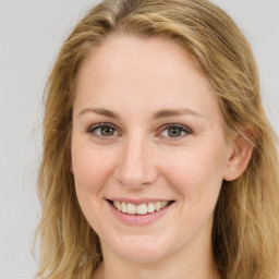 Joyful white young-adult female with long  brown hair and green eyes