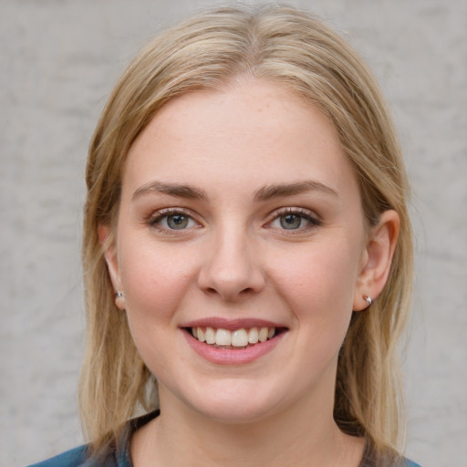 Joyful white young-adult female with medium  brown hair and blue eyes