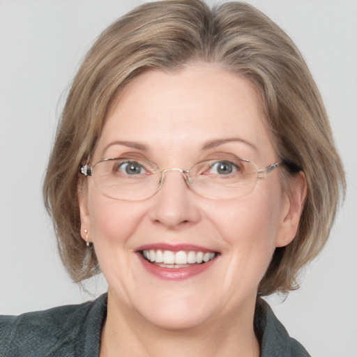 Joyful white adult female with medium  brown hair and blue eyes