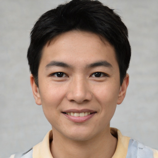 Joyful asian young-adult male with short  black hair and brown eyes
