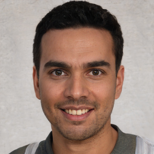 Joyful white young-adult male with short  black hair and brown eyes