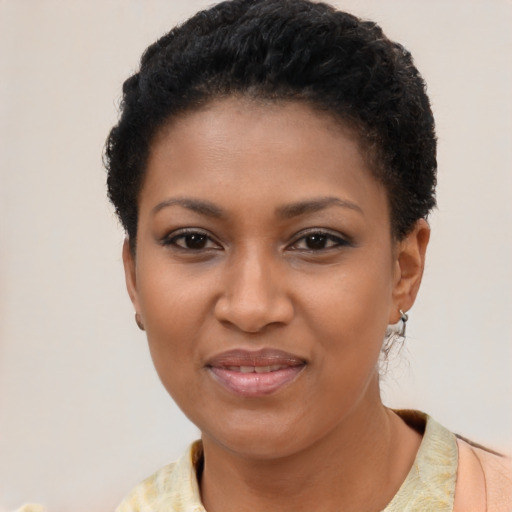 Joyful black young-adult female with short  black hair and brown eyes