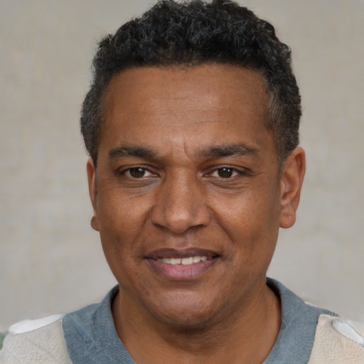 Joyful black adult male with short  black hair and brown eyes