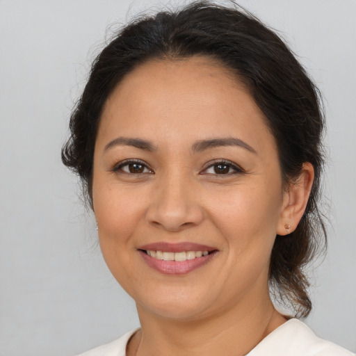 Joyful latino adult female with medium  brown hair and brown eyes