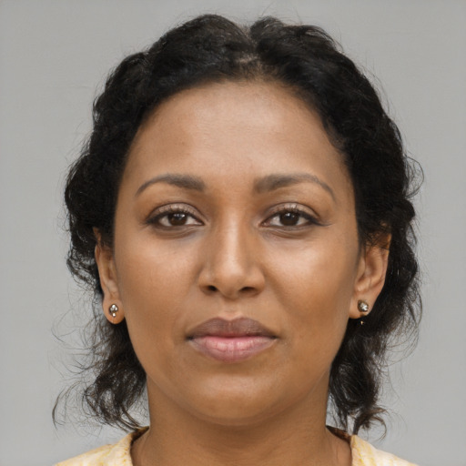 Joyful black adult female with medium  brown hair and brown eyes