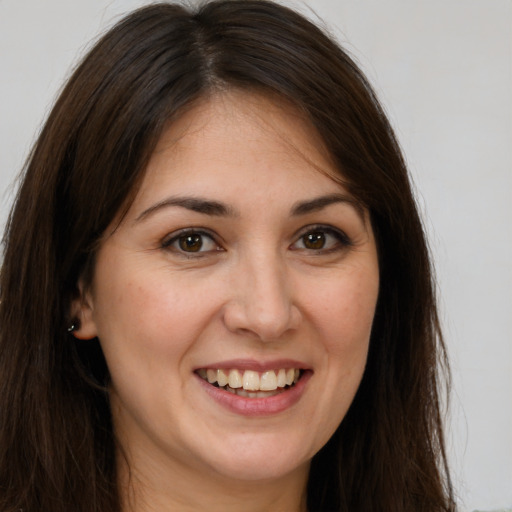 Joyful white young-adult female with long  brown hair and brown eyes