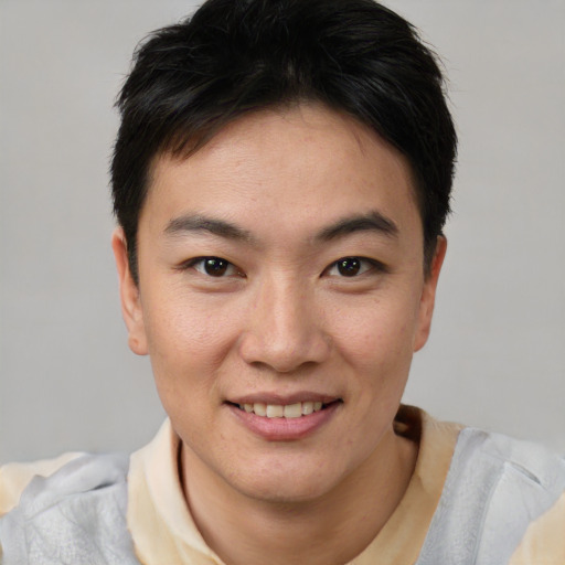 Joyful asian young-adult male with short  brown hair and brown eyes