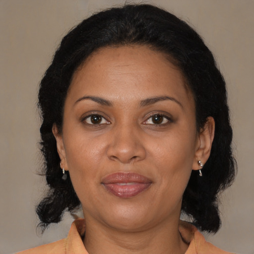 Joyful latino adult female with medium  brown hair and brown eyes