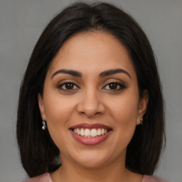 Joyful latino young-adult female with long  brown hair and brown eyes