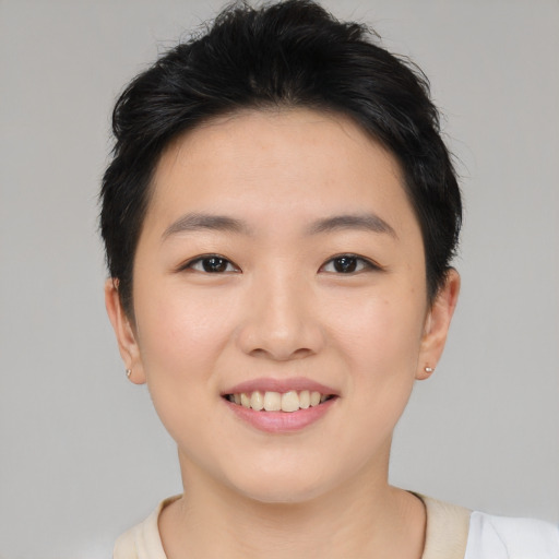 Joyful asian young-adult female with short  brown hair and brown eyes