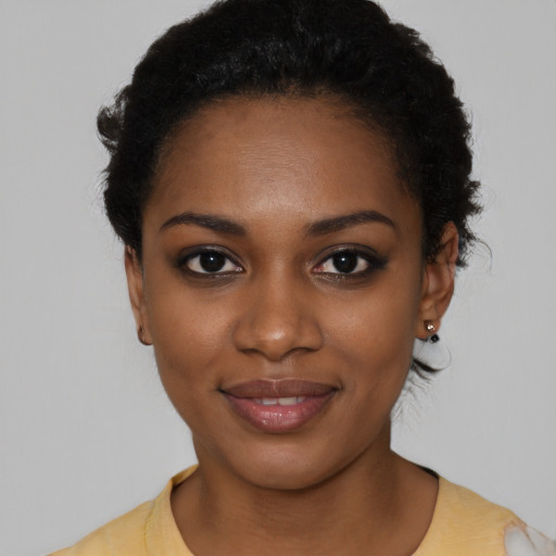 Joyful black young-adult female with short  black hair and brown eyes