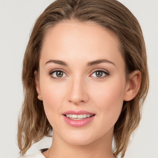 Joyful white young-adult female with medium  brown hair and green eyes