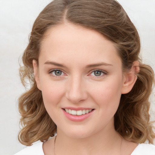 Joyful white young-adult female with long  brown hair and blue eyes