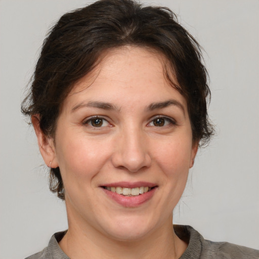 Joyful white adult female with medium  brown hair and brown eyes