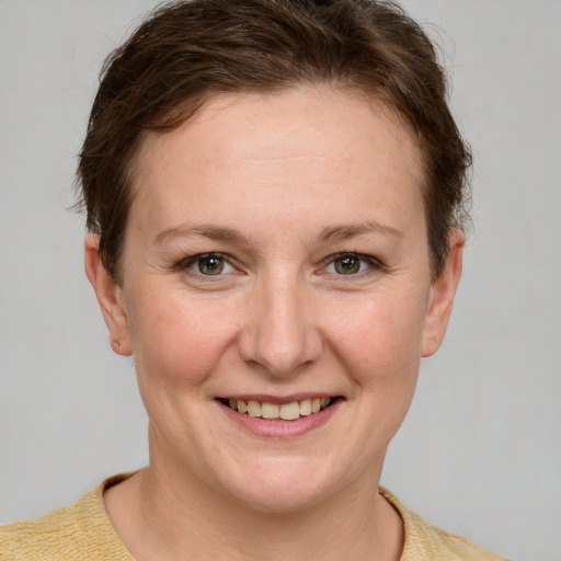 Joyful white young-adult female with short  brown hair and blue eyes