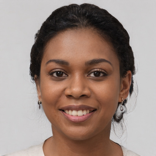 Joyful black young-adult female with medium  black hair and brown eyes