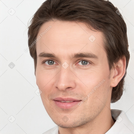 Joyful white young-adult male with short  brown hair and grey eyes