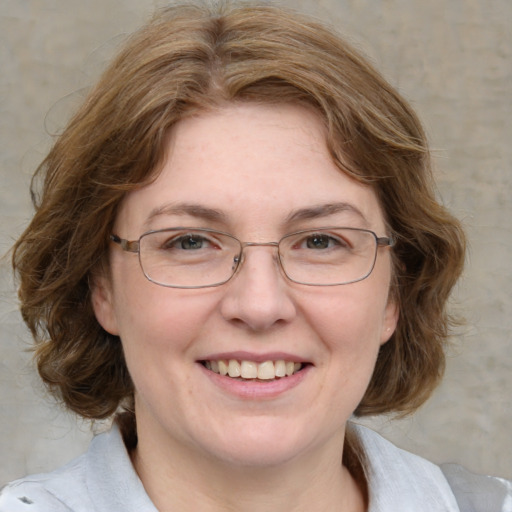 Joyful white adult female with medium  brown hair and blue eyes