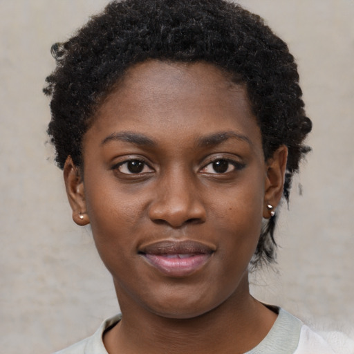 Joyful black young-adult female with short  black hair and brown eyes