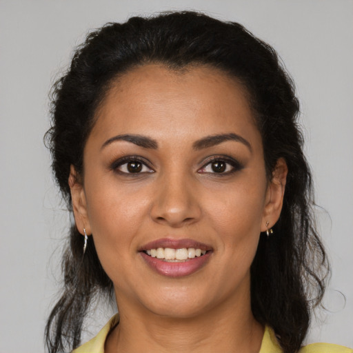 Joyful latino young-adult female with medium  brown hair and brown eyes