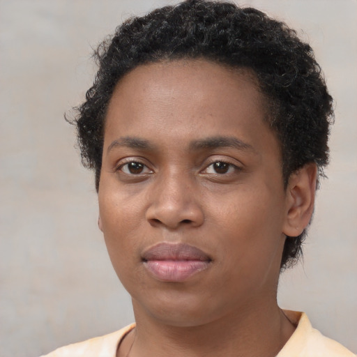 Joyful black young-adult female with short  brown hair and brown eyes