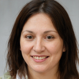 Joyful white adult female with long  brown hair and brown eyes