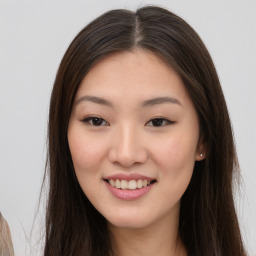 Joyful asian young-adult female with long  brown hair and brown eyes