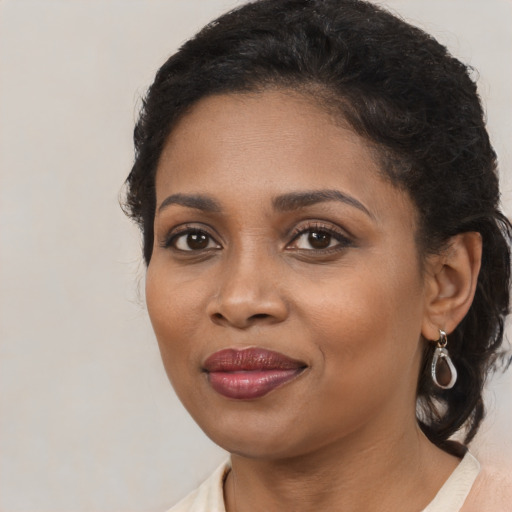 Joyful black young-adult female with long  brown hair and brown eyes