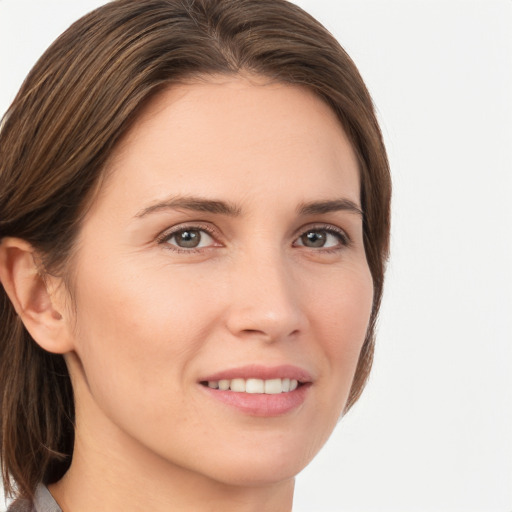 Joyful white young-adult female with medium  brown hair and grey eyes