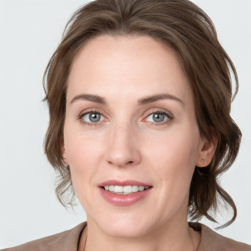 Joyful white young-adult female with medium  brown hair and blue eyes