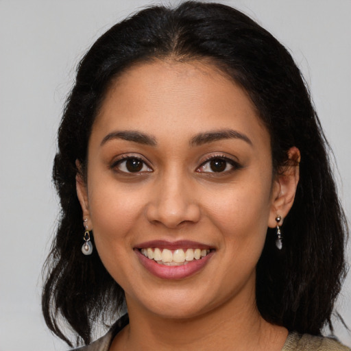 Joyful latino young-adult female with medium  brown hair and brown eyes