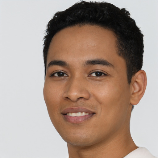 Joyful latino young-adult male with short  black hair and brown eyes