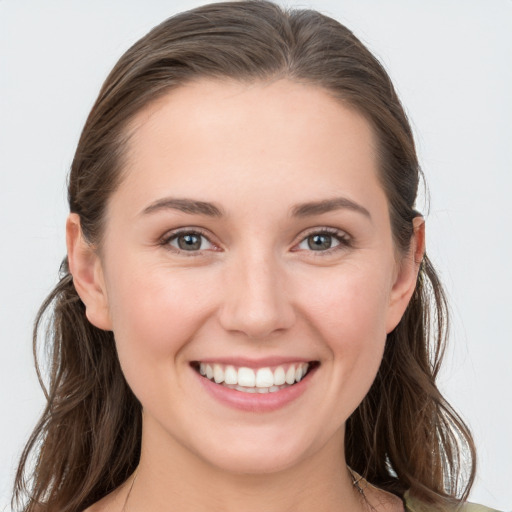 Joyful white young-adult female with long  brown hair and blue eyes