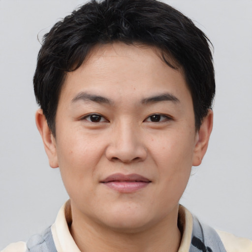 Joyful asian young-adult male with short  brown hair and brown eyes