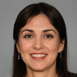 Joyful white adult female with long  brown hair and brown eyes