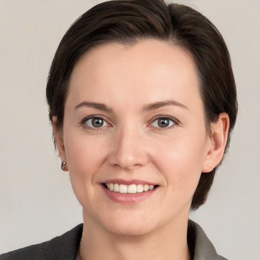 Joyful white young-adult female with medium  brown hair and grey eyes