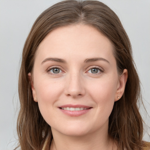 Joyful white young-adult female with long  brown hair and grey eyes