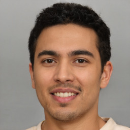 Joyful latino young-adult male with short  brown hair and brown eyes