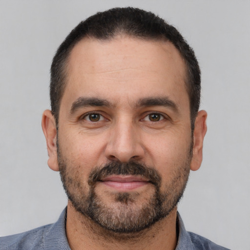 Joyful white adult male with short  black hair and brown eyes